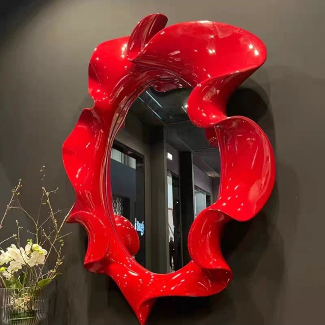 Red-edged sculptural mirror with bold artistic frame