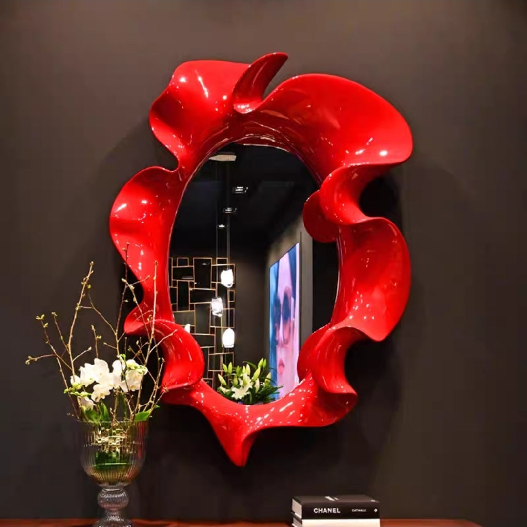 Red-edged sculptural mirror with bold artistic frame